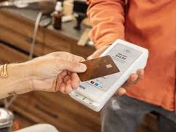 Person making a contactless payment with a card reader.