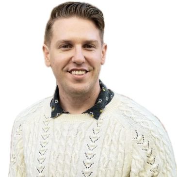 Smiling man in a white sweater.