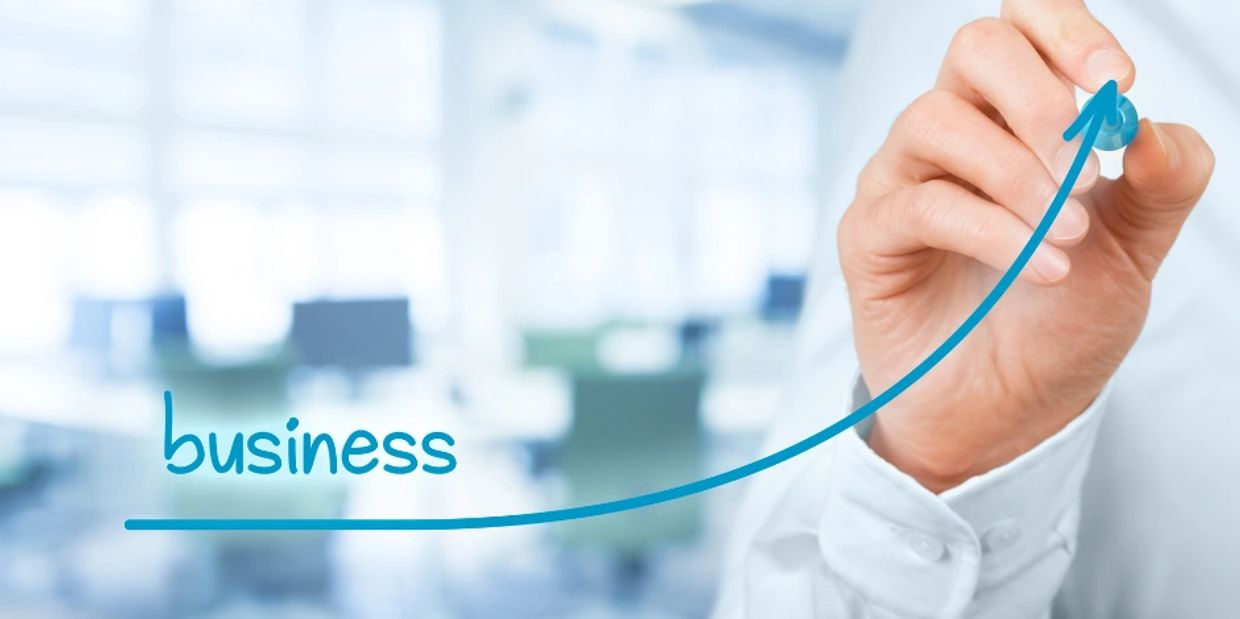 Hand drawing an upward arrow symbolizing business growth.