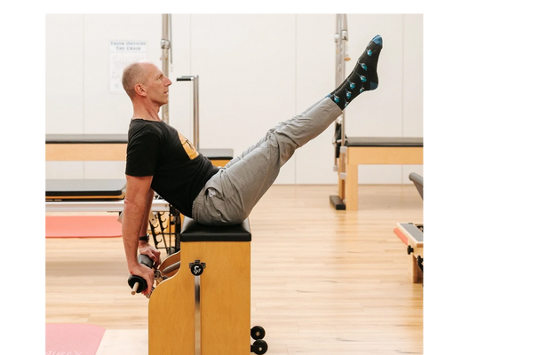 mike doing pilates on a reformer
