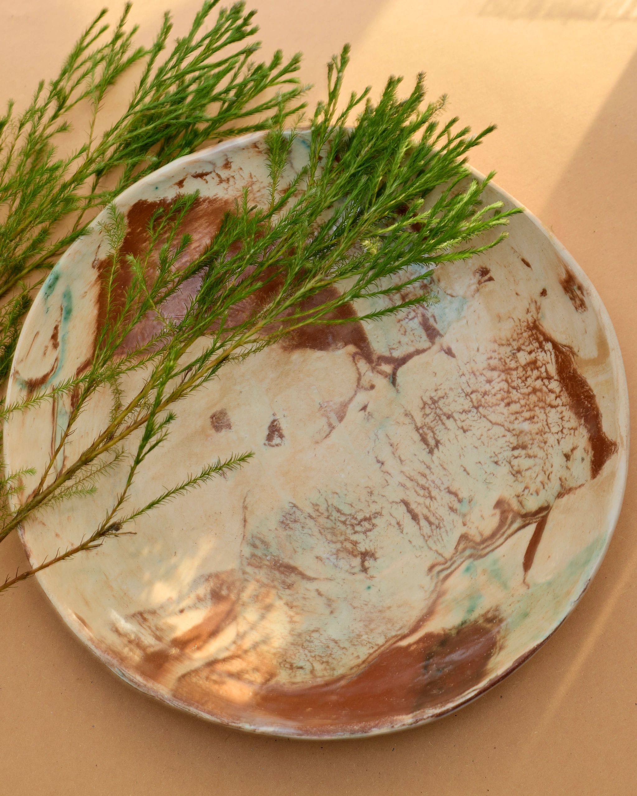 Decorative plate with greenery on a beige surface.