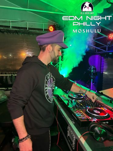 DJ playing EDM music at a vibrant night event in Philly.