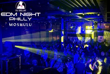 Crowd enjoying EDM night at Mosulu in Philly with vibrant blue and yellow lighting.