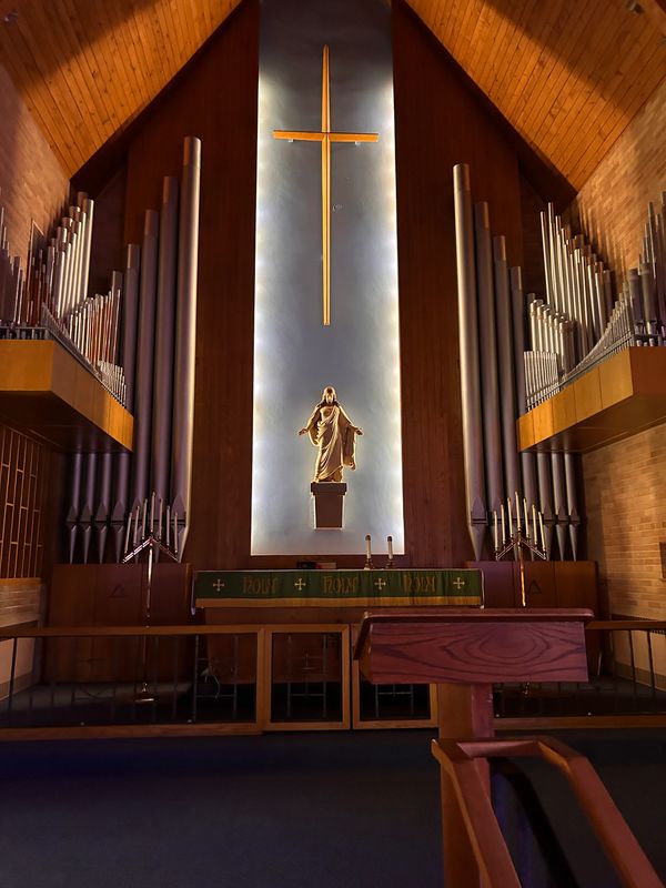 Church altar with cross and statue.