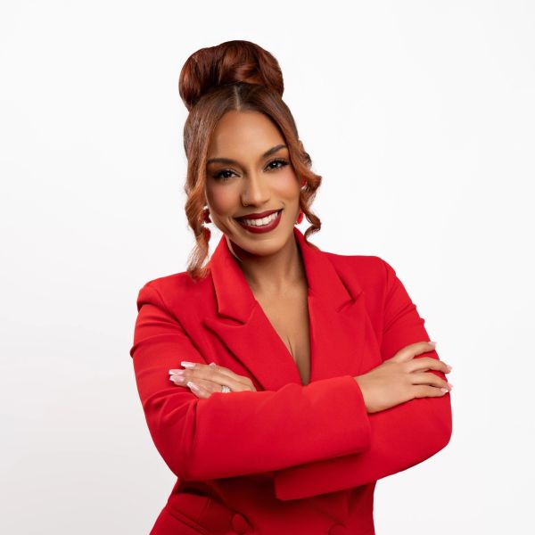 Confident woman in a red blazer smiling.