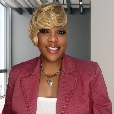 Smiling woman with blond hair and pink blazer.