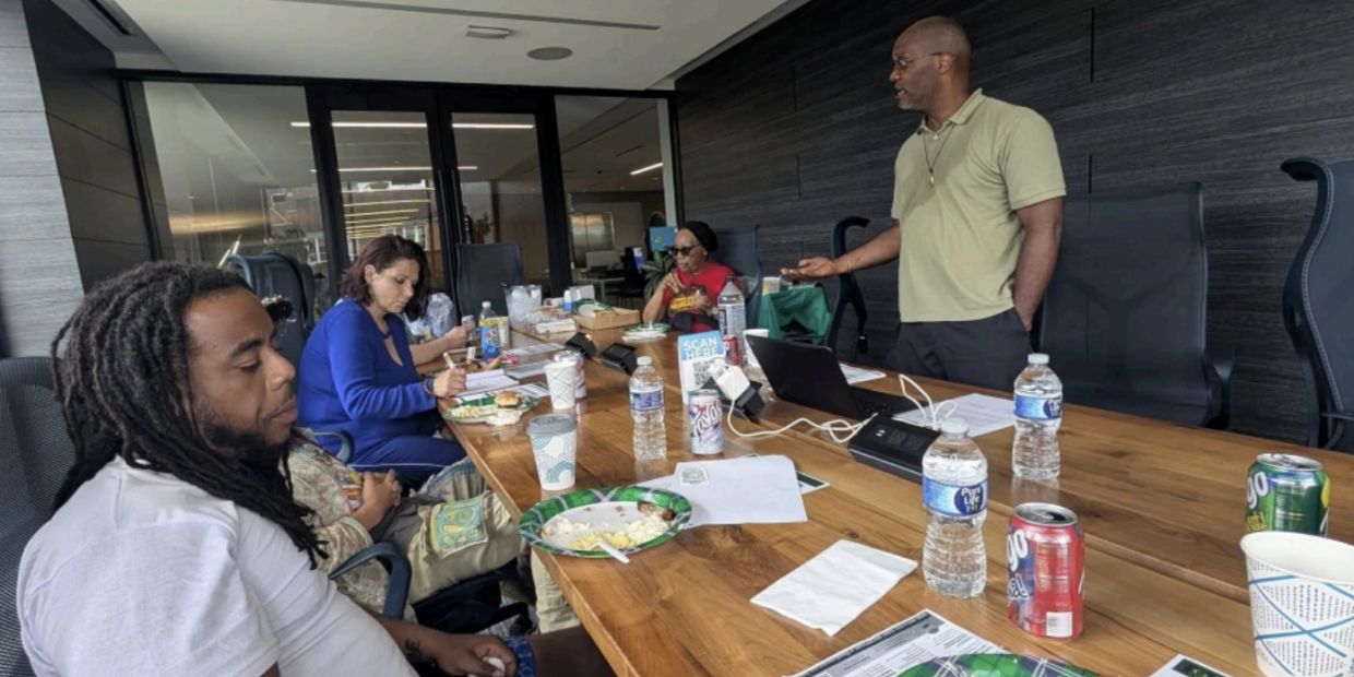 Group meeting with food and drinks at a conference table.