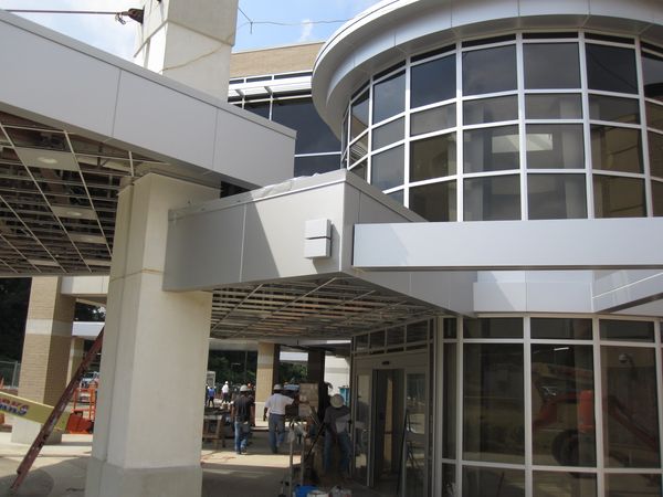 Construction workers working on a modern building's entrance.