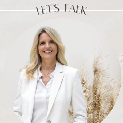 Confident woman in white blazer smiling with text 'Let's Talk' above.