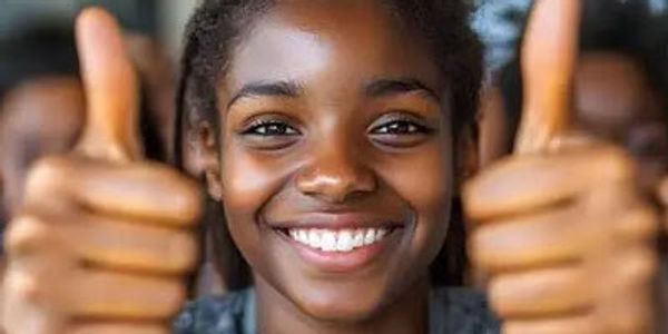 A smiling young woman giving two thumbs up.