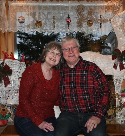 A couple wearing red outfits while sitting on a chair 