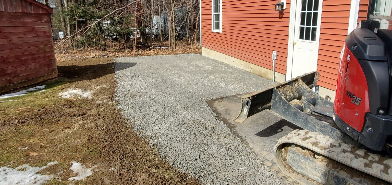 Creating a new crushed stone parking space for a camper in Sterling with thw grading bucket and mini