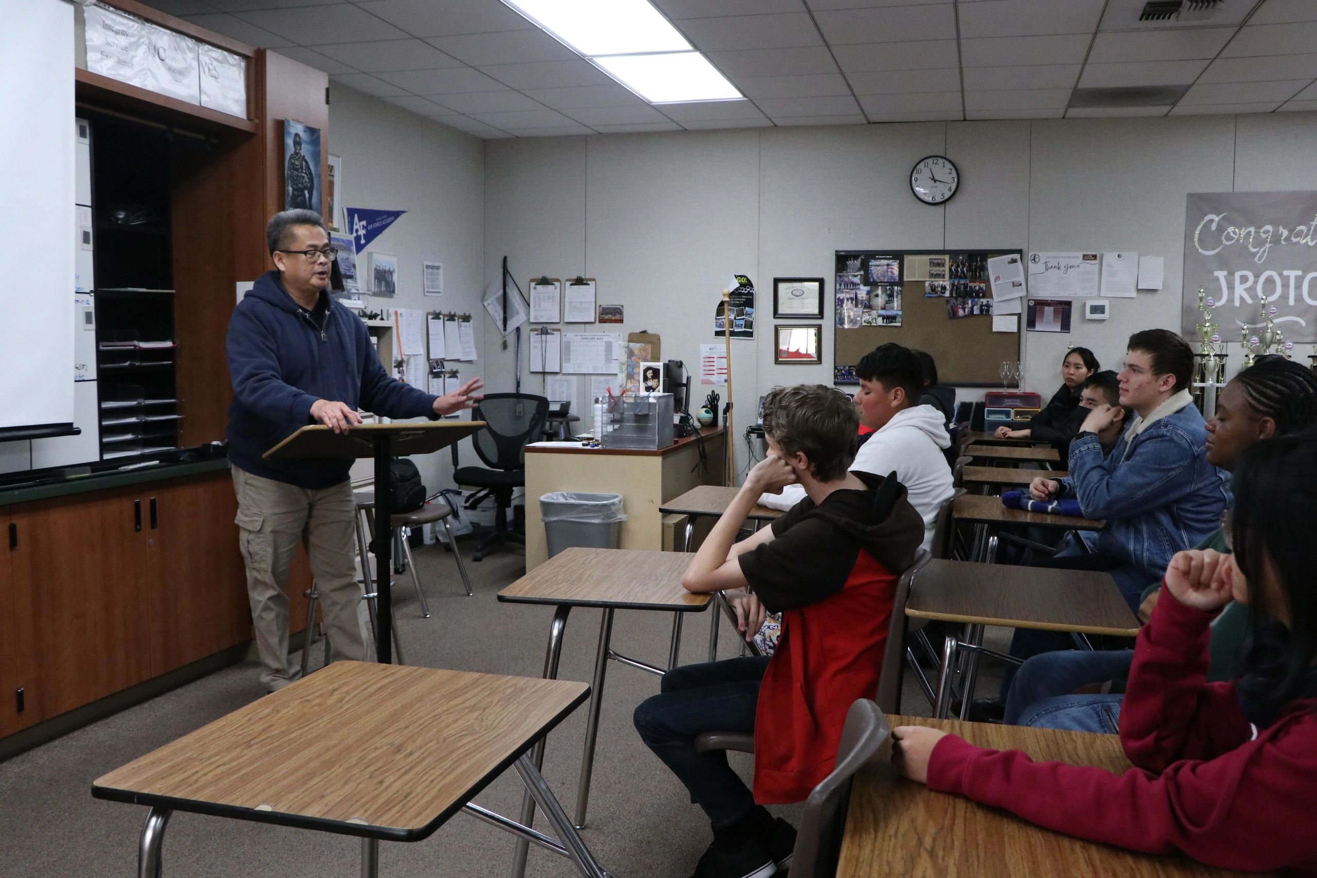 Teacher giving a lecture to attentive students in a classroom.