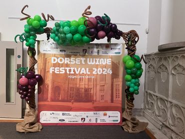 Balloon arch with grape clusters at Dorset Wine Festival 2024.
