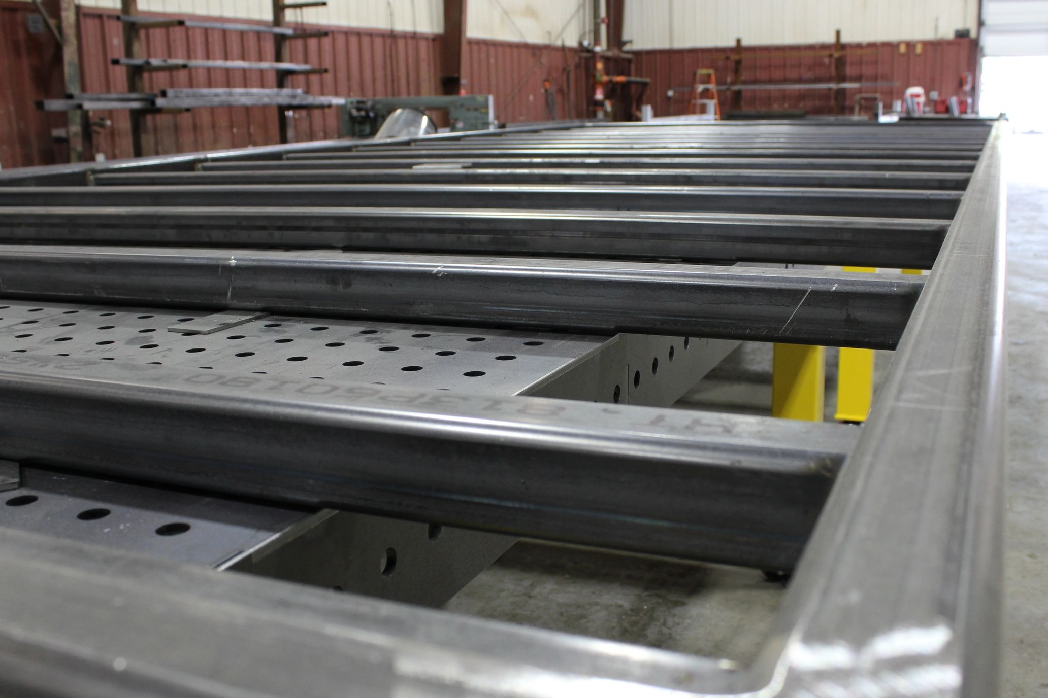 Metal beams arranged for industrial fabrication in a workshop.