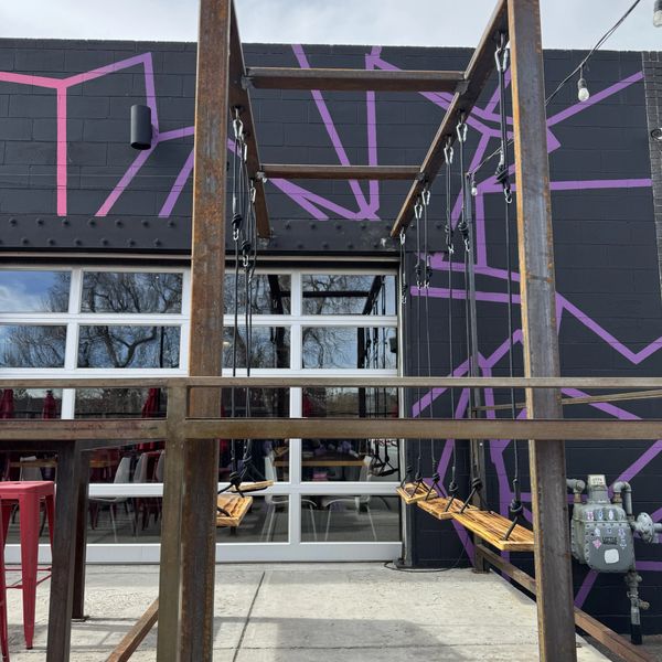 Image of a steel frame with swings at a local brewery