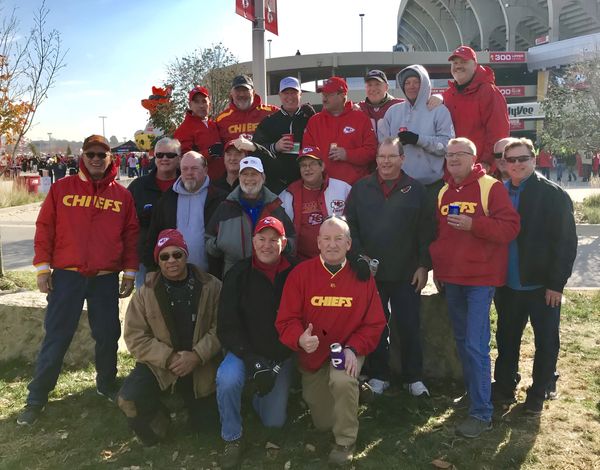 Group of people in Chiefs apparel pose outdoors.