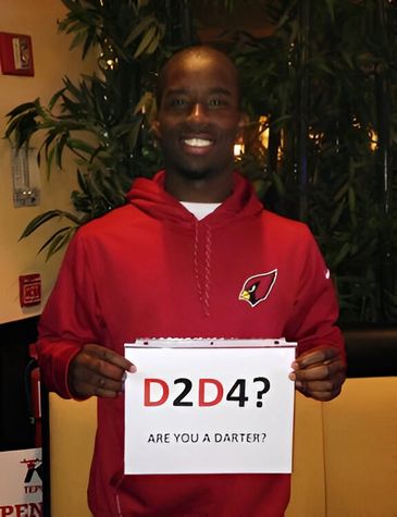Man in red hoodie holds "D2D4?" sign.