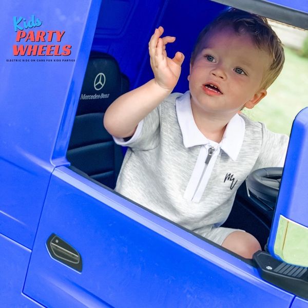 A boy in a blue lorry at a kids party wheels construction party. 