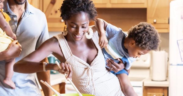 A joyful family cooking together in a bright kitchen.