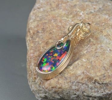 Colorful opal pendant with gold wire wrapping.