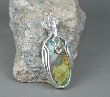 Wire-wrapped stone pendant with green and yellow hues.