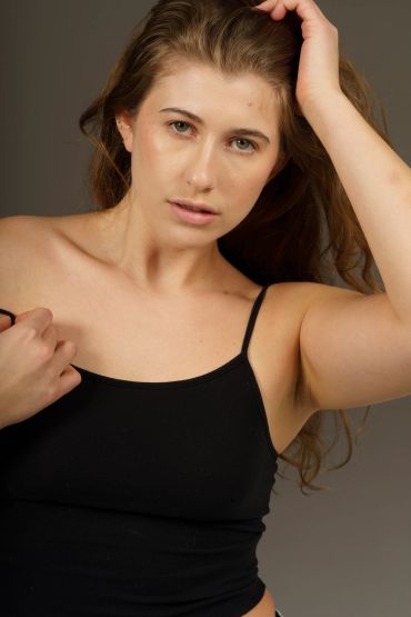 Woman with long hair in a black tank top.