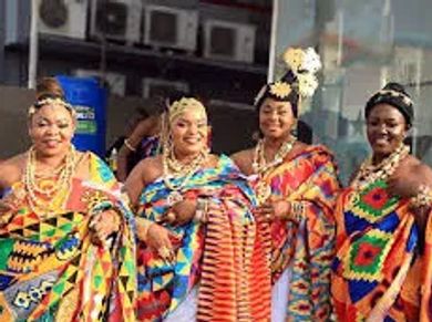 Four women in colorful traditional African attire and jewelry.
