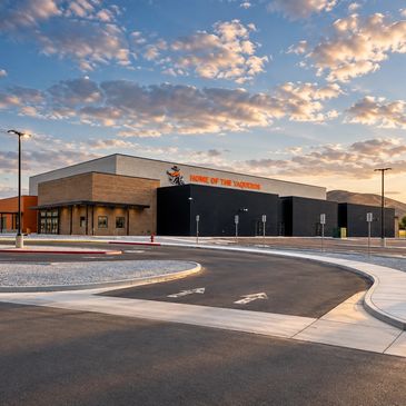Modern school building under a partly cloudy sky.