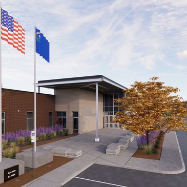 Modern building entrance with flags and landscaping.