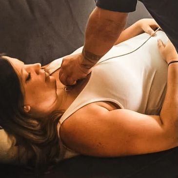 A woman receiving a medical checkup on her chest area.