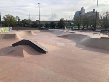 Empty concrete skatepark on a cloudy day.