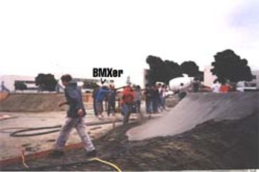 Group of people at a skatepark with BMX riders.