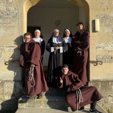 Group of people dressed as monks and nuns posing on stone steps.