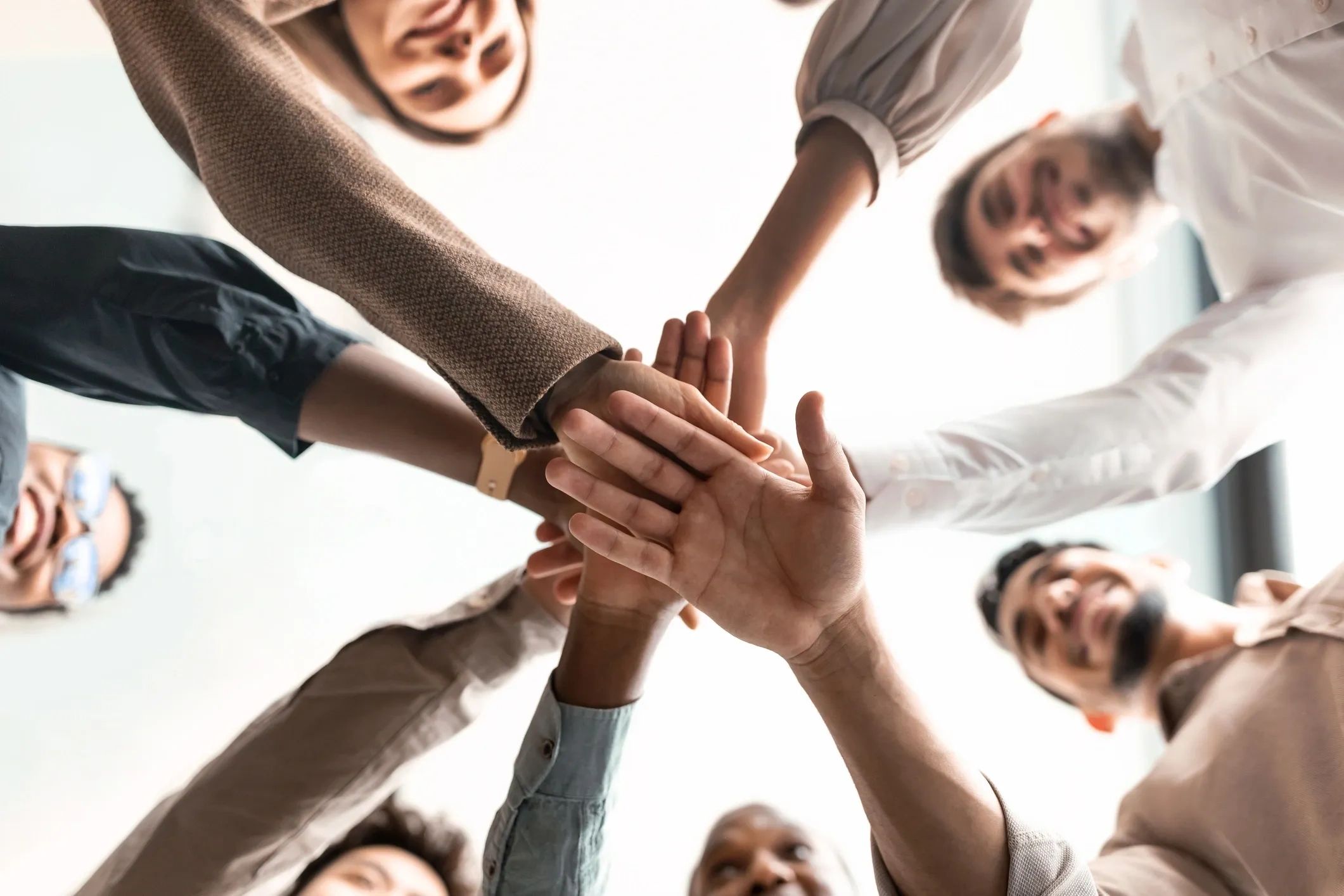 Group of people joining hands in unity.