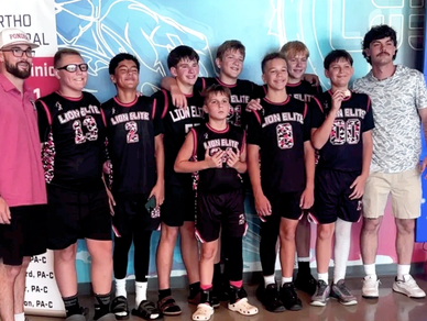 Youth basketball team posing for a group photo indoors.