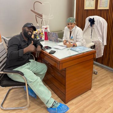 Patient and doctor giving thumbs up in dental clinic.