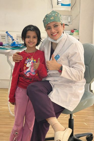 Smiling doctor and young patient giving thumbs up.