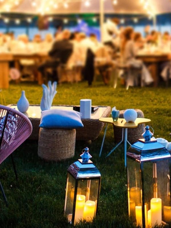 Outdoor gathering with lanterns and cozy seating.