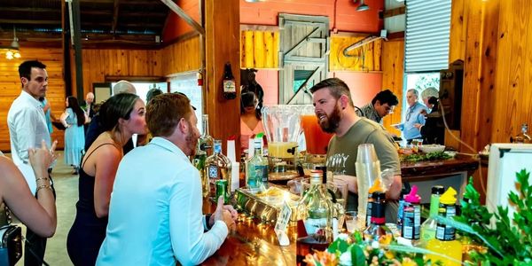 People socialize and enjoy drinks at a lively indoor bar with wooden decor.