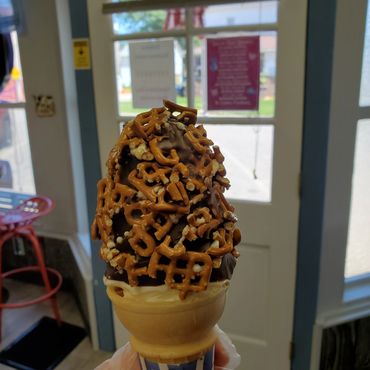 Soft serve ice cream, filled with caramel and dipped in chocolate, topped with crushed pretzels