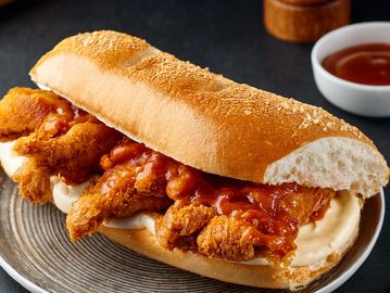 Crispy fried chicken sandwich with sauce on a fresh bun.