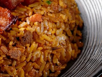 Close-up of seasoned rice with meat and vegetables in a bowl.