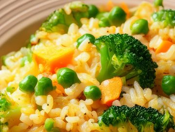 Close-up of colorful vegetable fried rice with broccoli, peas, and carrots.