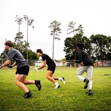 Football players performing explosive speed and agility drills at Route Tree Performance Tampa.