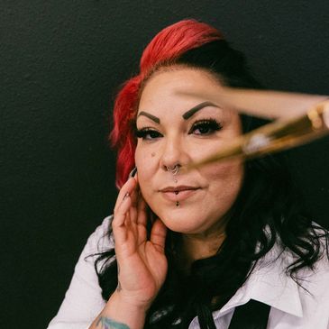 Woman with dyed hair and makeup brush.