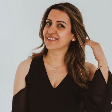 Smiling woman with shoulder-length hair in black dress.