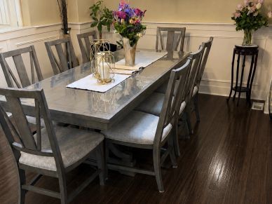 Elegant dining room with wooden chairs and flower centerpiece.