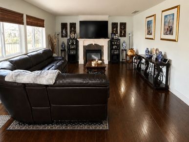 Cozy living room with leather sectional and fireplace.
