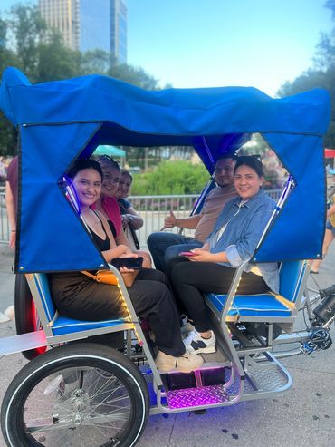 a family enjoying a spacious pedicab with cozy seating for up to six adults
